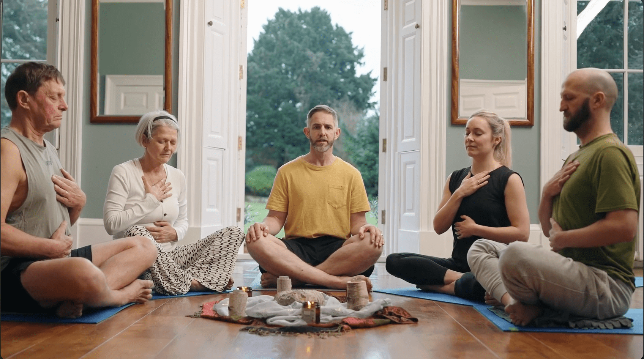 People sitting cross-legged on yoga mats in a peaceful indoor studio