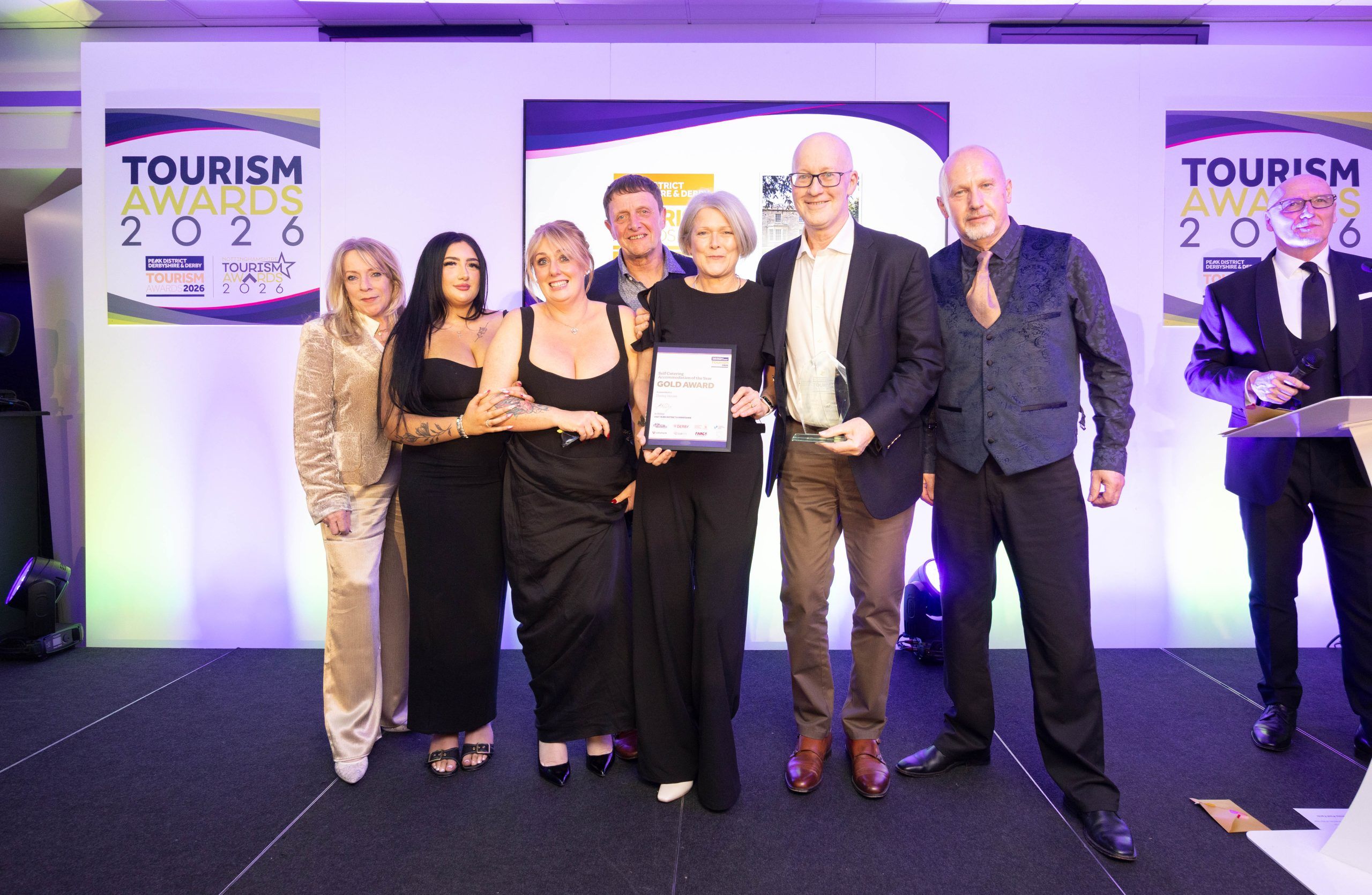 “Darley House team receiving the Gold Award for Self-Catering Accommodation at the 2026 Tourism Awards, standing on stage with the certificate and trophy.